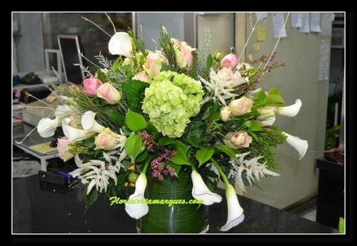 Centro en base de cristal con rosas , calas etc.